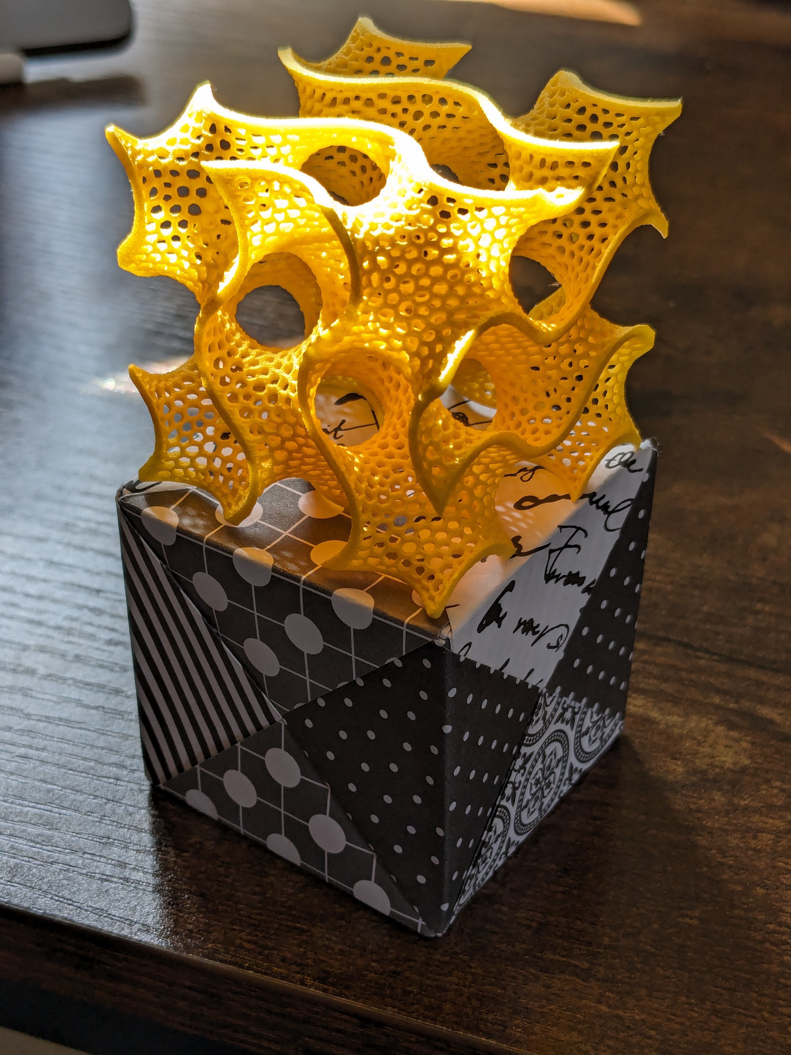 Gyroid model sitting on origami cube